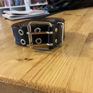 Svart bälte  - Lång, den passar de flesta för att man kan knäppa på vilket hål som helst