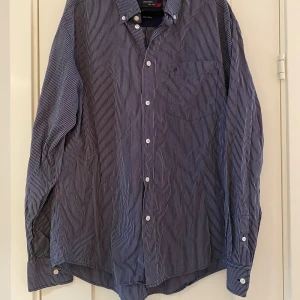 Marinblå och vit randig skjorta i strl XXL från RedGreen - Marinblå och vit randig skjorta i strl XXL från RedGreen.  Sparsamt använd och i fint begagnat skick.  Mått Över bröstet: ca 66 cm Längd från axeln och ner: ca 75 cm  100% egyptisk bomull   Kommer från ett djur och rökfritt hem. 