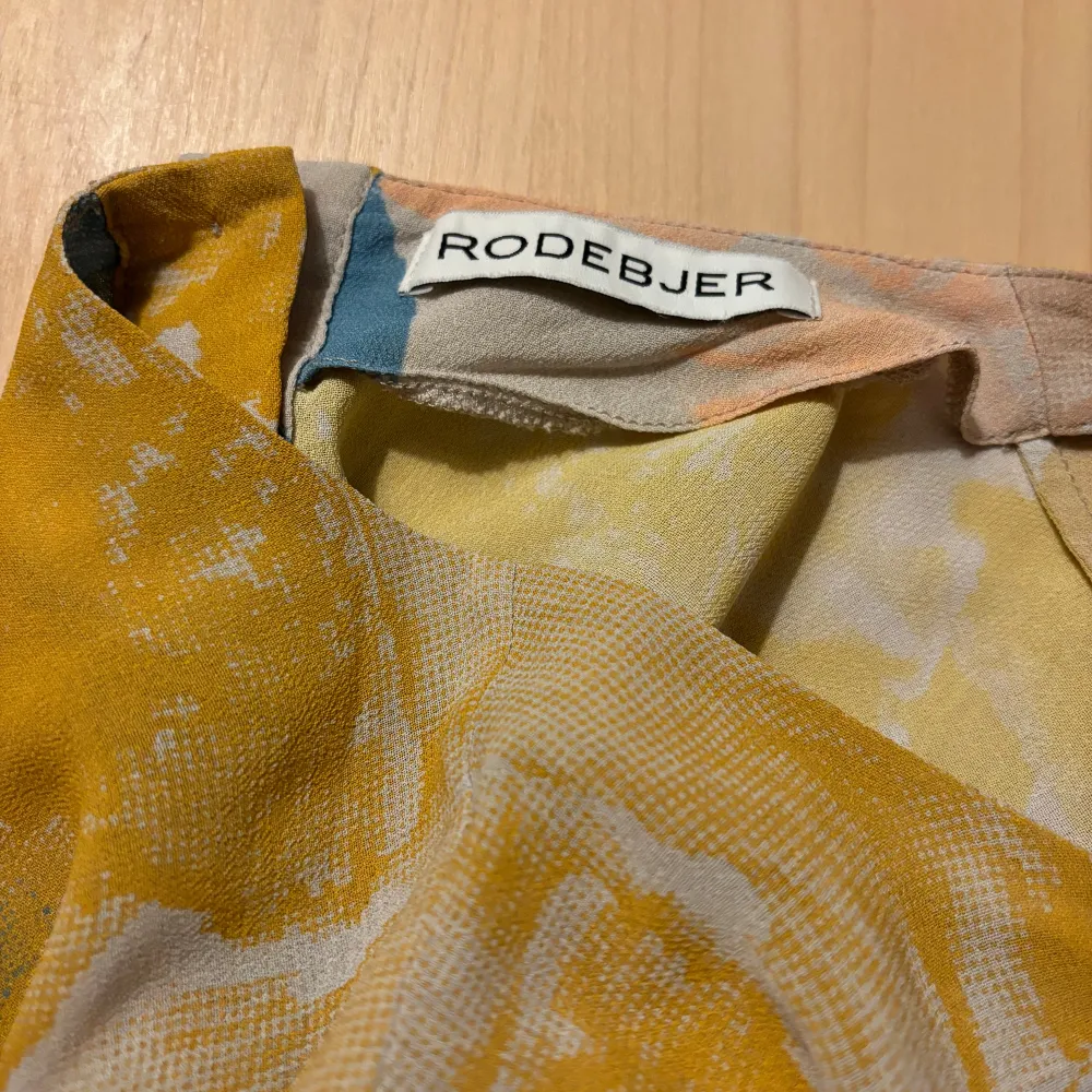 Designerblus Rodebjer i 100% viskos. Från märkets första resort kollektion 2015. Använd fåtalet gånger och säljer den nu. Storlek L men jag brukar själv ha S och den är lite stor. Knappar baktill som fin detalj. Jag är 166cm lång. . Blusar.