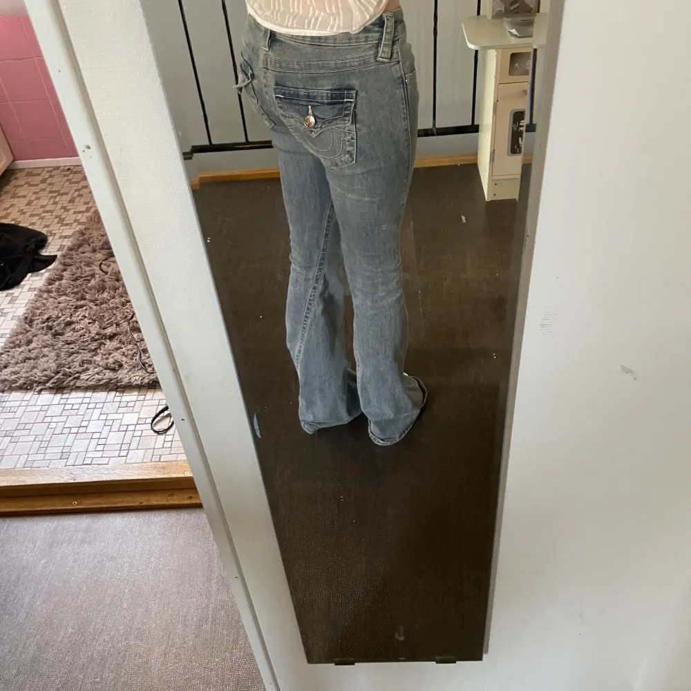 Säljer ett par snygga blå bootcut jeans i en klassisk stil. De är lågmidjade och har en lätt slitning framtill som ger en cool look. Perfekta för både vardag och fest!. Jeans & Byxor.