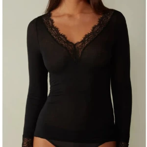 Intimissmi tröja - Säljer en elegant svart långärmad topp med v-ringning och fina spetsdetaljer vid halsen och ärmsluten. Perfekt för både vardag och fest! 