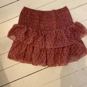 Röd mönstrad kjol med volang - Säljer en superfin röd kjol med mönster köpt på en butik i Spanien för 400 🤗 har smått glitter i sig som man kan se på tredje bilden 🩷🫶kan gå ner i pris 😊