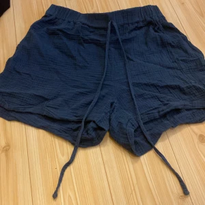  Linne shorts Blåa  - Ett par fina linne shorts i färgen blå med väldigt långt snöre på och hög midja