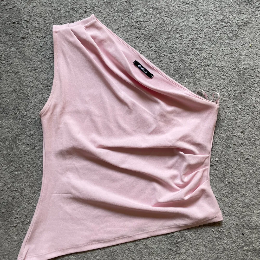 Säljer en superfin rosa oneshoulder topp från GinaTricot. Den är perfekt för sommaren och har en tight passform som framhäver figuren. Det passar för både vardag och fest. Använt fåtal gånger men annars är tröjan som nyskick.. Toppar.