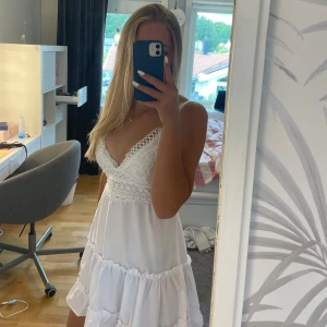 Vit sommarklänning med öppen rygg - Jag säljer en helt oanvänd sommarklänning med knyte i ryggen. Den har aldrig kommit till användning vilket är anledningen till att ja nu säljer den🥰 Skriv vid frågor eller intresse🥰