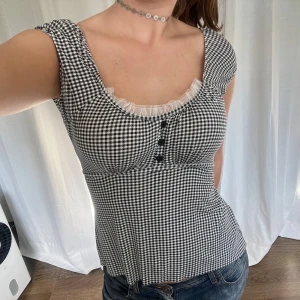 Rutig topp - Svart vit rutig topp med spetsdetalj från Risøe. Knyts i ryggen, stretchigt material 🖤