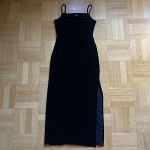 Svart långklänning från JP Collection - Svart långklänning från JP Collection! Klänningen är i mjukt sammet med smala axelband och slits i sidan vid ena benet. 