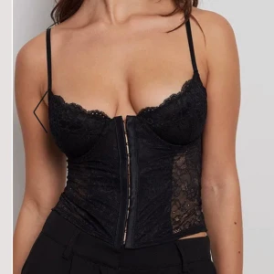 Korsett i spets - Aldrig använd svart korsett i spets från NAKD med alla lappar kvar. Säljer för jag beställde flera storlekar och skickade inte tillbaka i tid. Storlek 70C.