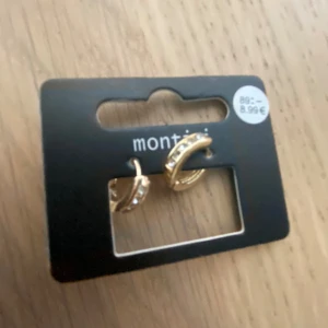 Guldörhängen från Montini och Ur&Penn - Säljer två par snygga guldörhängen. paret är från ur&Penn och har en elegant design med små glittrande stenar. har en klassisk, slät guldyta. Perfekta för både vardag och fest!