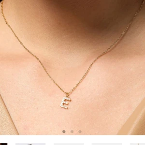 guld halsband bokstaven ”E” - jättefint guld halsband med bokstaven ”E” använd 2 gånger men har köpt ett med mitt namn istället och av den anledningen används den inte, 