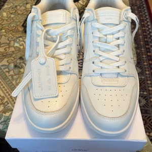 Vita sneakers från Off-White - Säljer ett par vita sneakers från Off-White i skinn. De har en stilren design med snörning och en cool Off-White tagg. Perfekta för både vardag och fest. Skorna är i nyskick och kommer i originalförpackning.