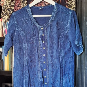 Broderad tunika - Unik blå tunika med broderi. Lite lösa trådar här och där (bör därför inte tvättas alltför ofta). Sparsamt använd. Nypris 350kr.