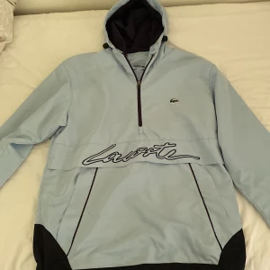 Lacoste tracksuit - denna baby blå Lacoste tracksuit är helt perfekt för hösten, vill du att byxorna ska vara mer baggy? Så finns de en dragkedja som du kan dra upp för o göra den emr baggy, pris kan diskuteras.