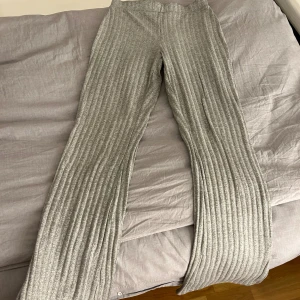 Gråa mjukisbyxor - Gråa mjukisbyxor som är utsvängda vid benen och som har slits. Storleken är S och är använd ett par gånger. Byxan är i mycket god skick.