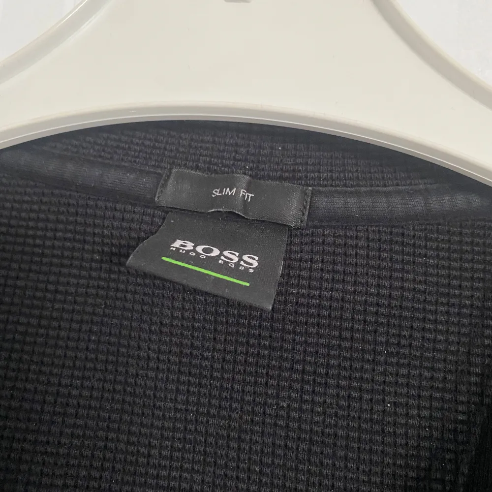 Snygg svart tröja från Hugo Boss med guldig logga på bröstet. Tröjan har en slim fit passform och långa ärmar. Perfekt för en stilren look. Den är som helt ny men säljs för att den inte passar min stil längre. Pris går alltid att diskuteras.. Hupparit & Collegepaidat.