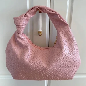 Rosa Flätad Axelväska - Supersnygg flätad rosa handväska med ett jättesött knutformat handtag. Helt oanvänd, perfekt inför sommaren💕💕