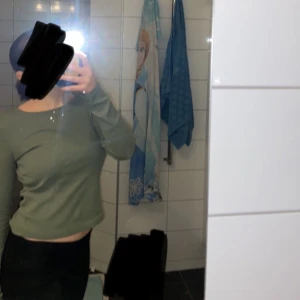 Olivgrön långärmad topp - Säljer en olivgrön långärmad topp med en croppad passform. Kommer aldrig till andvändnig längre så Aa den är i storlek 170 men skulle kunna säga att den skulle passa en som har S-M typ💕