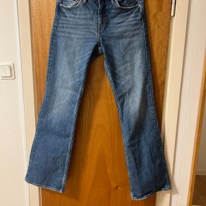 Blå bootcut jeans - Snygga blå bootcut jeans med klassisk femficksdesign. Perfekta för en avslappnad stil. De har en bekväm passform och är tillverkade i slitstarkt denim.