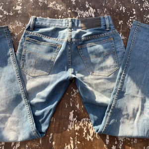 Blå skinny jeans - Snygga blå skinny jeans med klassisk femficksdesign och kontrastsömmar. Perfekta för en stilren look. De har en diskret läderpatch baktill vid midjan.