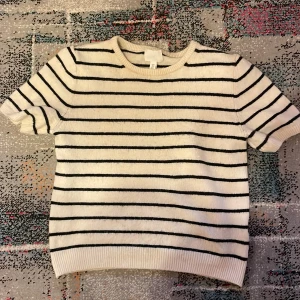 Randig tröja från H&M - Säljer en stilren vit/lite beige kanske (ej säker pp färgen) och svart randig tröja från H&M. Tröjan har korta ärmar och en rund halsringning. Perfekt för en avslappnad look. Har använt den ca 5 gånger, alltså är den ganska ny. Storlek S. betalar ej frakt!!💞