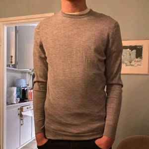 Grå kashmir- och silkeströja från Suitsupply - Säljer en elegant grå tröja från Suitsupply i en lyxig blandning av kashmir och silke. Tröjan har en klassisk design med långa ärmar och rund halsringning. Perfekt för en stilren look. Inga defekter. Har krympt till Xs-S