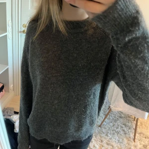 Mörkgrå stickad tröja - Säljer en mysig mörkgrå stickad tröja med långa ärmar. Perfekt för kyliga dagar och enkel att matcha med olika outfits. Helt slutsåld från Zara. Nypris 450