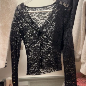Svart spetstopp  - Snygg långärmad spetstopp med v-ringad hals. Klippt av lappen där det står storlek osv så man kan ha den bakochfram. Original pris 300kr