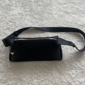 Svart väska Primark - En snygg och användbar väska med gulddetaljer. Använd två gånger. Innerfack med dragkedja på  insidan.