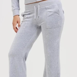Grå mjukisbyxor från Juicy Couture - Snygga grå mjukisbyxor från Juicy Couture med broderad logga. Byxorna har en bekväm passform med snörning i midjan och praktiska fickor både fram och bak. Perfekta för en avslappnad dag hemma. Snygga och bekväma grå juicybyxor med snörning i midjan! BYXORNA ÄR UPPSYDDA, passar mig fortfarande och jag är 157. Skriv privat för mer information om byxorna och eventuellt prissänkning/höjning! Håller ej kvar de i väntan på något. Billigare vid snabb affär💰 JAG STÅR INTE FÖR FRAKTEN.