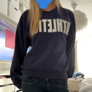 Mörkblå sweatshirt med text - Säljer en mörkblå sweatshirt med texten 'ATHLETIC' i vitt från Gina tricot 💓💓