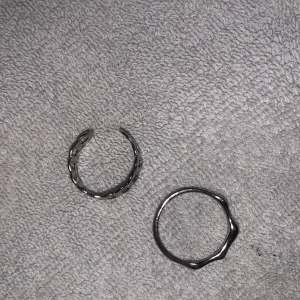Två silverringar - Säljer två stilrena silverringar. Den ena har en kedjedesign och den andra har en vågig form. Perfekta för att bära tillsammans eller var för sig för en minimalistisk look.