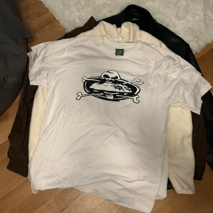 Vit t-shirt med tryck - Säljer en vit t-shirt med ett coolt svart tryck på framsidan. Perfekt för en avslappnad stil. T-shirten har en klassisk passform och rund halsringning.