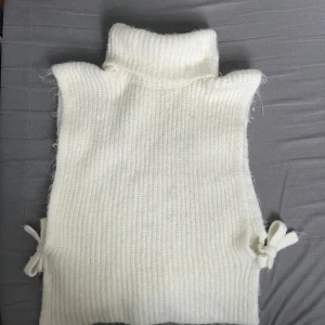 Stickad vest med polo krage  - Super snygg vit stickad vest med polo krage i bra skick. Knyts vi sidorna. Köpt för 500 säljer för 200. Från Lindex i storlek s men passar även xs eller m!