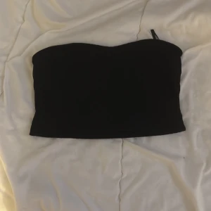 Svart tubtopp - Snygg svart tubtopp perfekt för en stilren look. Enkel design som passar till många olika outfits.