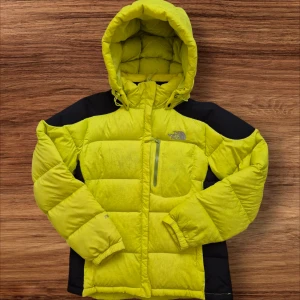 Gul dunjacka från The North Face size L neon green - Säljer en gul dunjacka från The North Face med svarta detaljer. Jackan har en huva och en praktisk bröstficka med dragkedja. Perfekt för kalla dagar med sin pufferdesign och långa ärmar. Excellent condition  Goose down  Warm and puffy  Good for medium to large size  Ask me if you have questions
