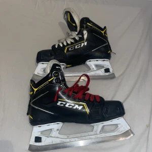 Målvakts skridskor CCM-Super tacks 9380 - Svarta CCM-målvakt skridskor med vita och röda snören. Skridskorna var använda i ungefär 1 1/2 säsong. Man kan se att dom är använda men i användnings syfte så är det inget fel på dom.