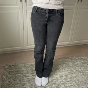 washed black jeans från monki - Snygga långmidjade jeans i färgen washed black. De har en knapp och dragkedja framtill samt fickor både fram och bak.