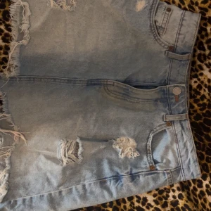 Ljusa jeansshorts från FB Sister - Snygga ljusa jeansshorts från FB Sister med slitna detaljer och fransiga kanter. Perfekta för en avslappnad stil. De har en klassisk femficksdesign och knappgylf. Säljer då jag gått upp i vikt och den ej går över mina höfter