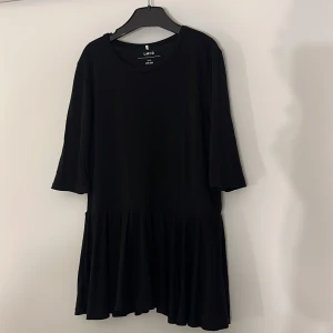 Svart blus från LMND - Hejj! Just nu säljer jag denna fina kortärmade blus i storlek 146-152. Den passar även mig som brukar ha XS eller S. Den ser längre ut på bilden men är inte lika lång annars. Blusen har en volang längst ner! Säljer då den inte används längre. Den är i mycket fint skick. Jag säljer denna för 65kr men pris kan diskuteras om man hör av sig. Skriv om ni har några frågor☺️
