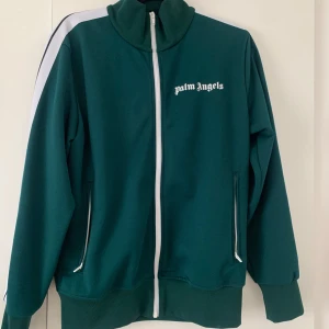 Grön track jacket från Palm Angels - Så gott som ny. Inköpt från NK för 4699 k. Kvitto och etiketter finns kvar.                                                     Mitt pris: 2000kr prutat och klart.