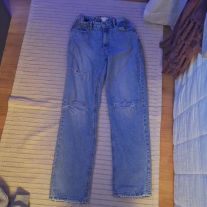 Blå jeans med hål - Säljer ett par blå jeans med coola hål på framsidan. De är köpta från Gina tricot i stl 164. Otroligt bra skick, sparsamt använda och inga defekter💞💞