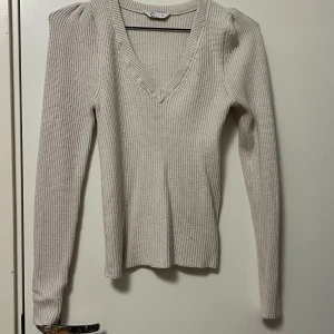 Krämfärgad stickad tröja - Svårt att få med på bild men tröjan har små ”axelvaddar”