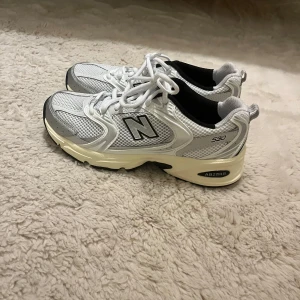 Vita sneakers från New Balance - New balance 530. Vita sneakers, med silver detaljer och beige sula. Aldrig använda. 
