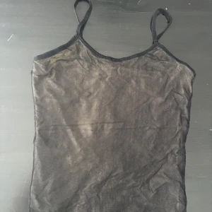 Svart mesh linne - Snyggt svart mesh linne med smala axelband. Perfekt för lager-på-lager eller som ett statement-plagg. Enkel och stilren design som passar till många olika outfits. Finns ett under tyg under som är typ sandfärgat. PRIS KAN DISKUTERAS 
