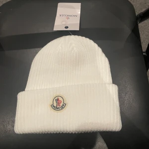 Moncler mössa - Snygg vit mössa från Moncler. Helt oanvänd. Säljer eftersom jag helt enkelt insåg att mössa inte är något för mig.