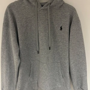 Grå hoodie från Ralph Lauren - Snygg grå hoodie från Ralph Lauren med klassisk logga på bröstet. Den passar som en M.