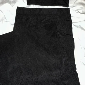 Lång kjol och bandeu topp - Snygg svart lång kjol med matchande bandeu topp från Gina Tricot. Materialet är lite glittrigt, syns på andra bilden. Kom privat för fler bilder🥰