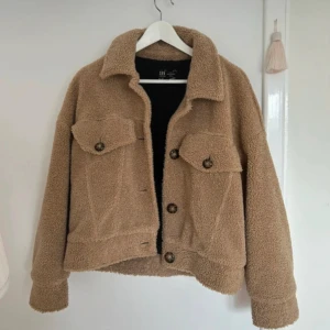 Beige teddyjacka med knappar - Mysig beige teddyjacka med knappar och två bröstfickor. Perfekt nu till vintern. 