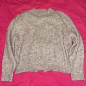 Beige stickad tröja från Carin Wester - Mysig beige stickad tröja från Carin Wester i storlek XS. Perfekt för kyliga dagar med sin mjuka och varma känsla. Tröjan har långa ärmar och en klassisk rund halsringning.