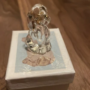 Glashund  - Säljer en liten glashund med små guldfärgade detaljer. Den packas i bubbelplast och en låda med vaderad insida så den inte ska gå sönder i frakten. 